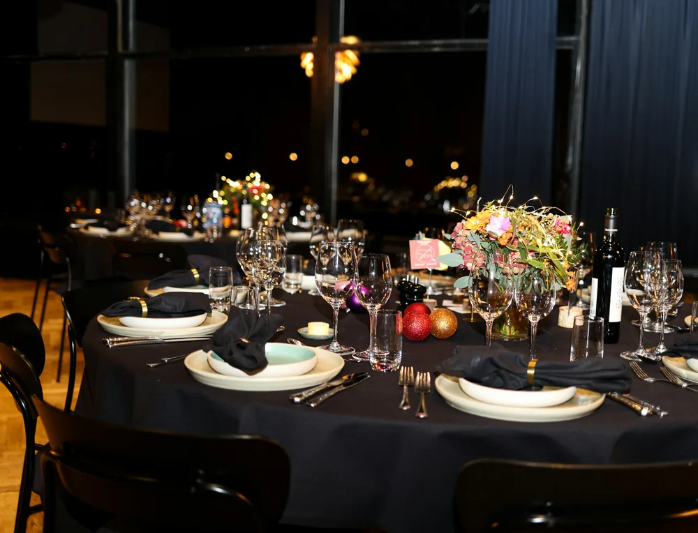 A dark-linen gala table with florals and candlelight
